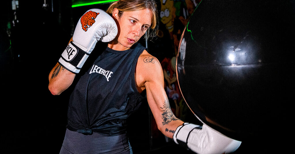 Uppercut boxe : notre coach Anne K envoyant un uppercut dans un aqua bag