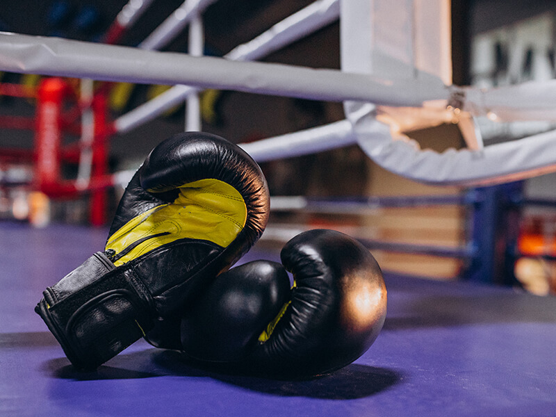 Une paire de gants de boxe posée sur un ring