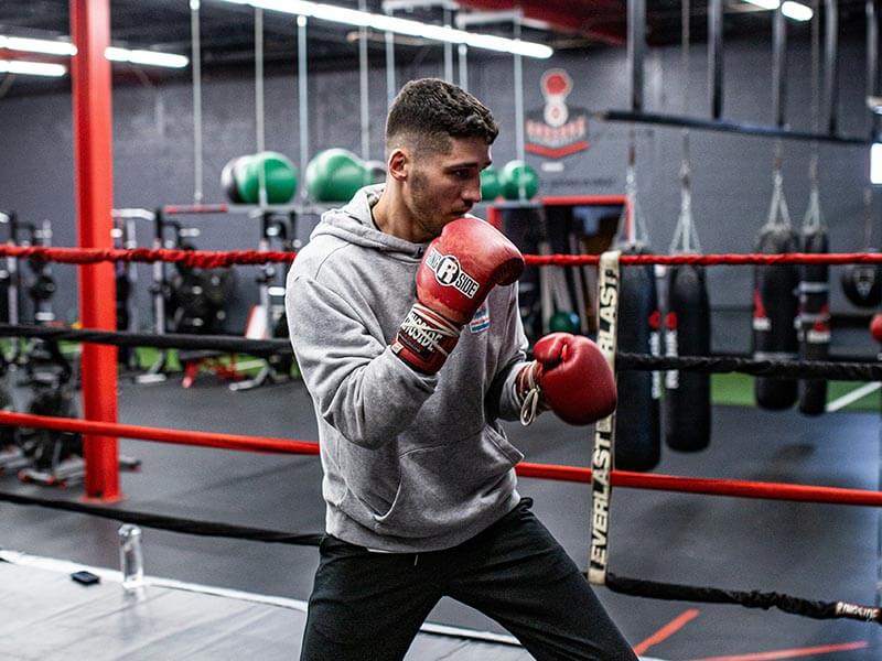 Un boxeur qui s'entraine en faisant du shadow boxing sur un ring