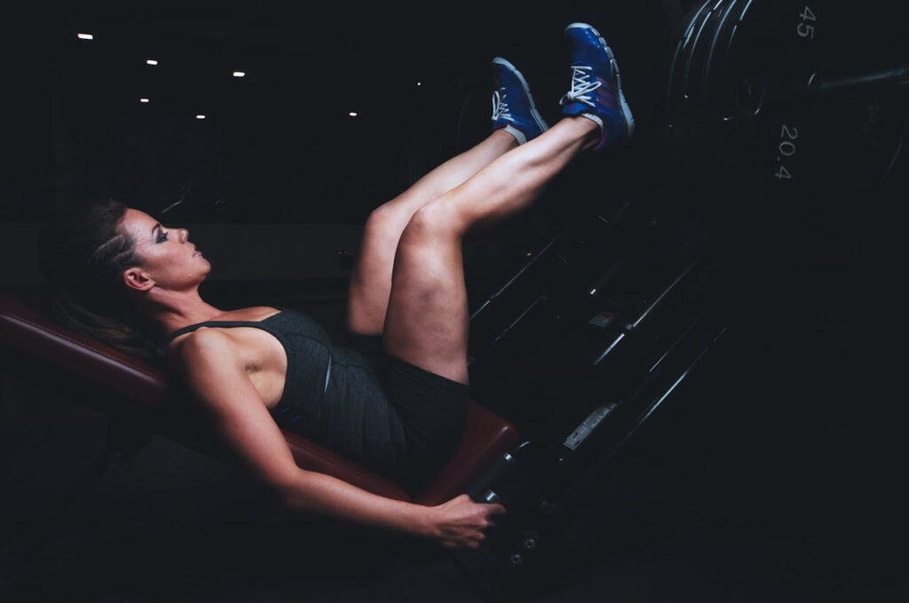 exercices avec un banc de musculation : une femme fait un exercice pour les jambes
