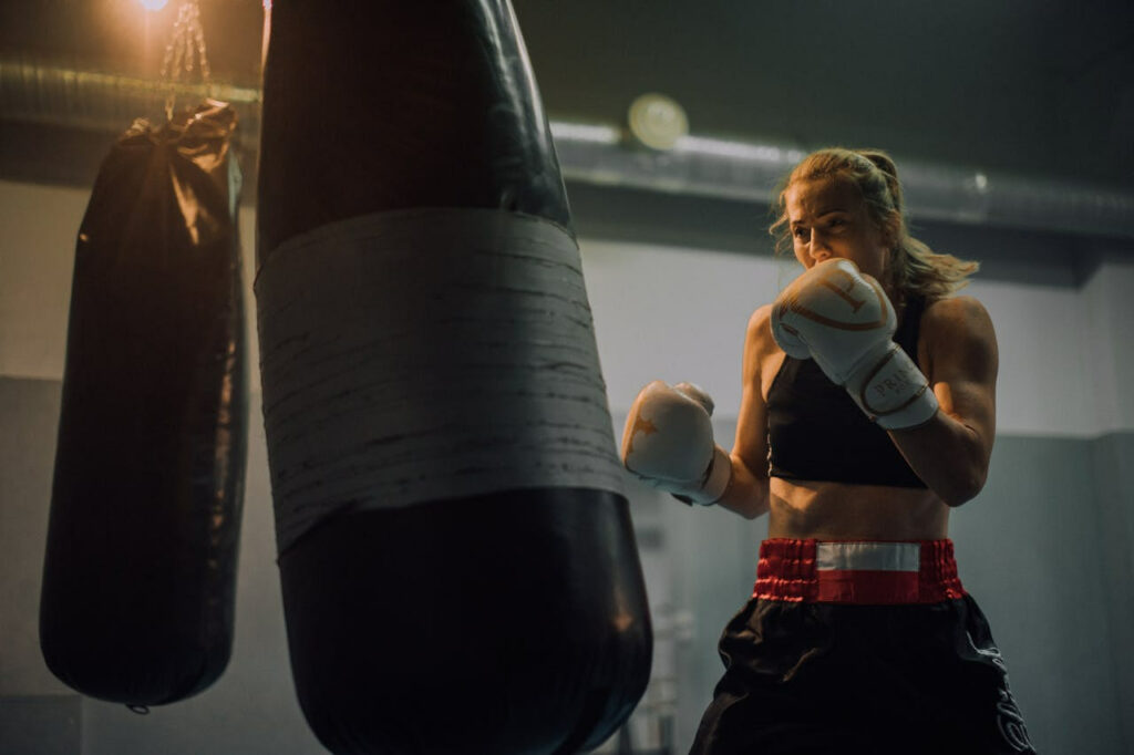 Exercice explosivité boxe : Une femme frappe dans un sac de frappe