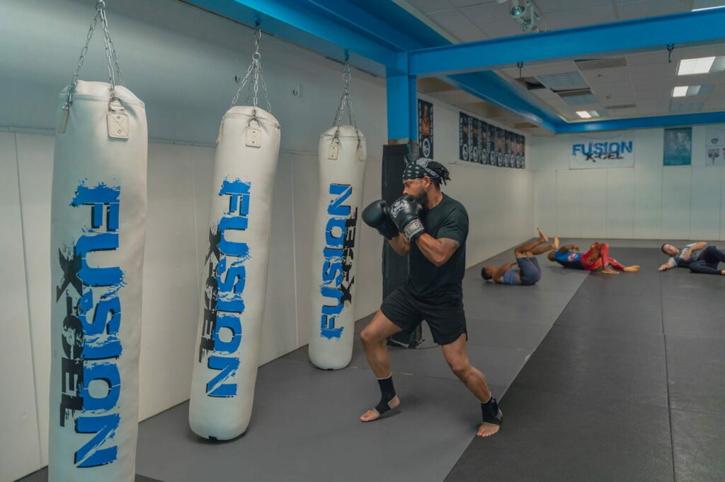 Un homme s'entraîne en hiit boxing sur un sac de frappe