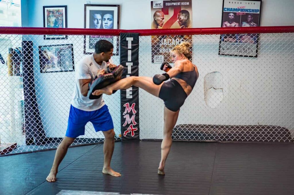 Quelle est la boxe la plus dangereuse : une femme s'entraîne à donner des coups de pieds en boxe