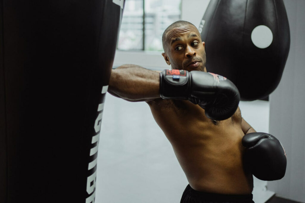 Un homme s'entraîne en hiit boxing sur un sac de frappe