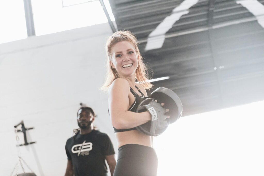 Boxe pour maigrir : une femme sourit en tenant des pattes d'ours